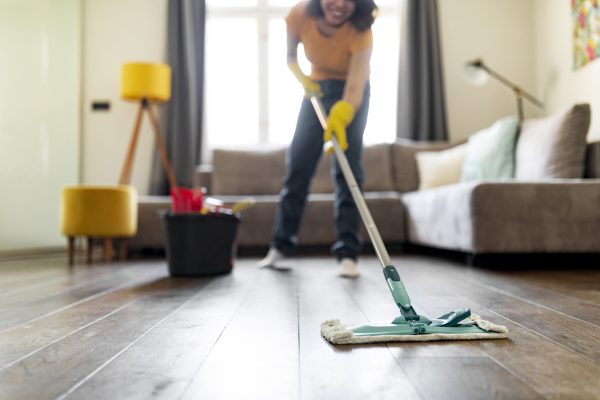 Smiling Young Woman Washing Floor In Living Room With Mop, Happy Millennial Female Making Spring-Cleaning At Home, Mopping Dirty Surface With Detergents, Enjoying Domestic Chores, Selective Focus